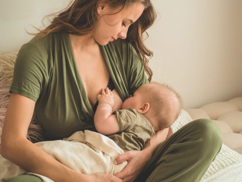 Mom breastfeeding baby on lap