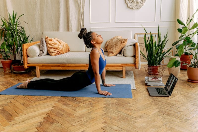 A woman doing yoga at home as an example of self care for busy moms