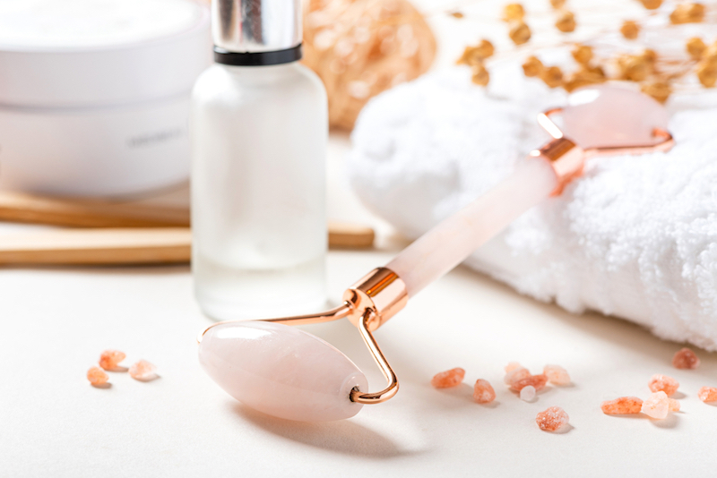 Rose quartz facial roller with beauty products