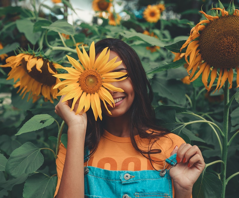 Woman smiling with sunflower