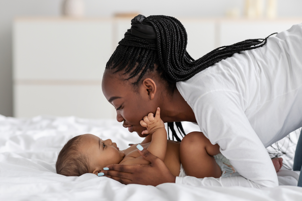 African American Mom kissing baby on the cheek 