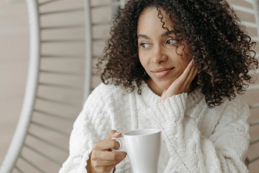 Overstimulated mother enjoying a warm beverage indoors, exuding comfort and relaxation.