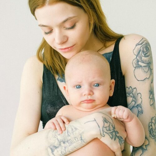 identity in postpartum mom with tattoos holding baby.jpg