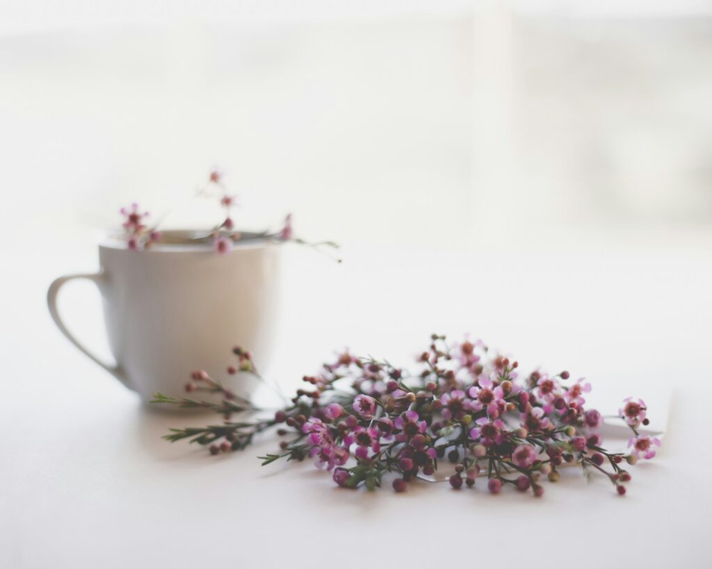 micro moments of self care pink and green flowers on white ceramic teacup