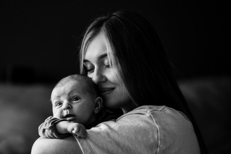 postpartum recovery, a woman holding a baby in her arms