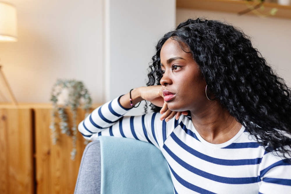 woman grieving pre-motherhood identity sitting on couch