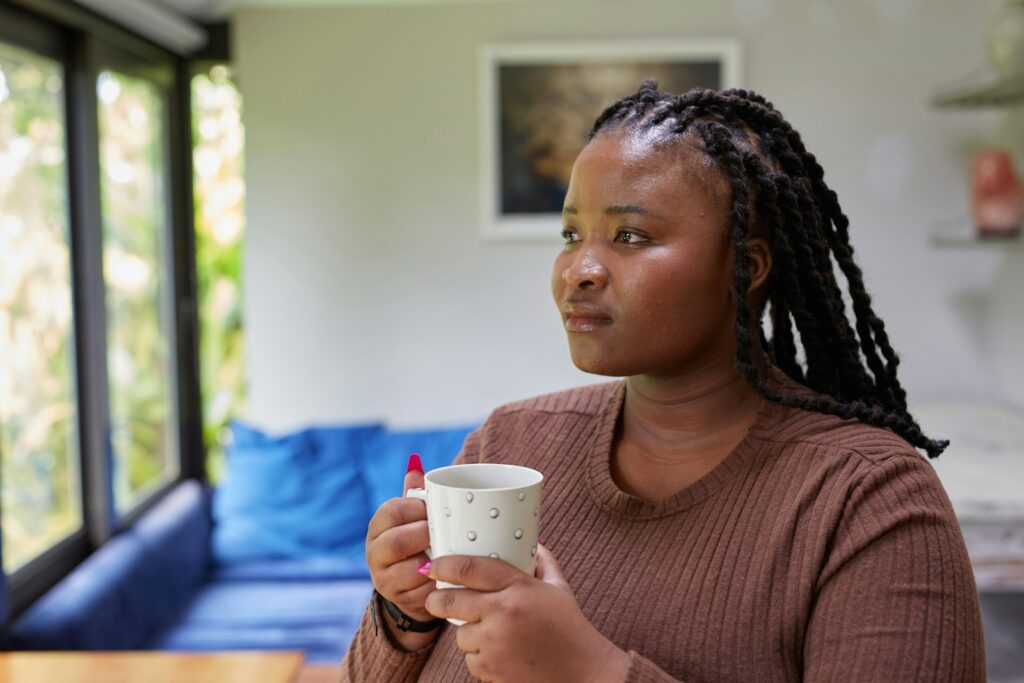 woman thinking about past moment, holding a cup