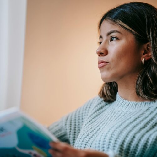 why moments stay with you in motherhood, woman thinking reading on couch